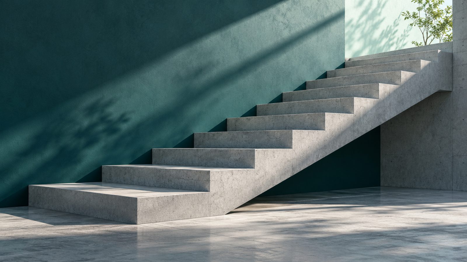A concrete staircase rising against a deep teal wall in soft morning light